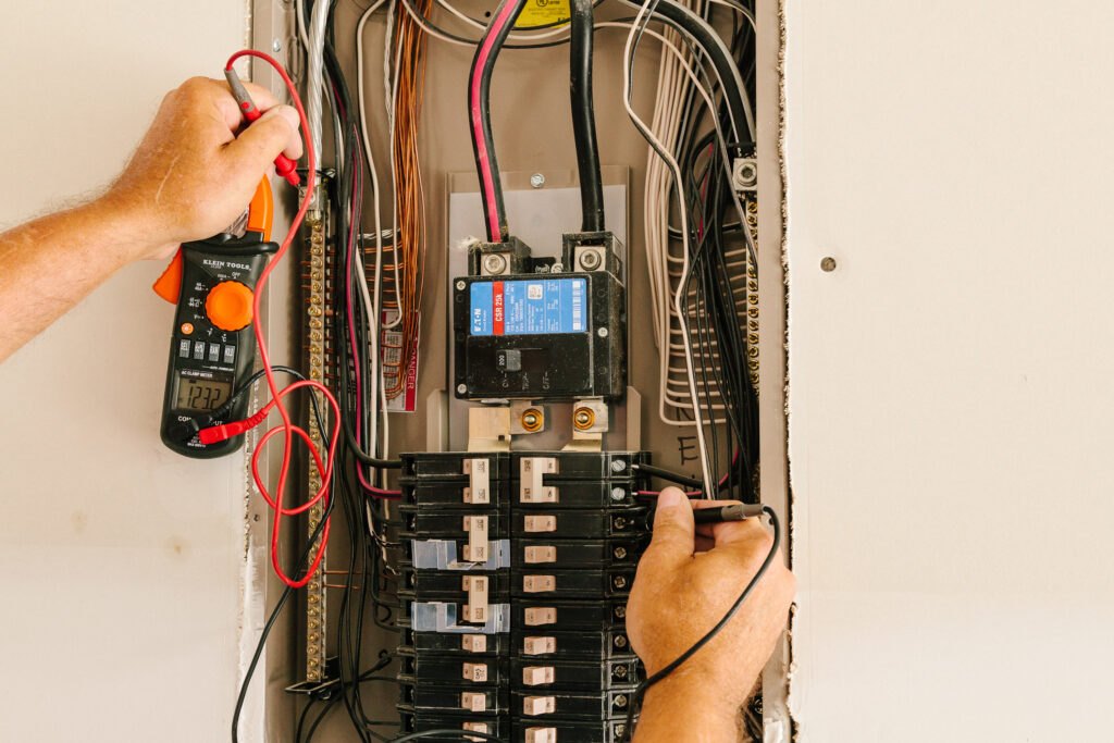 Electrician testing a residential breaker panel with an electrical tester